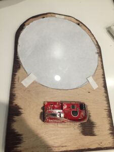 The graphic is secured by a circular piece of plexiglass and gaffers tape